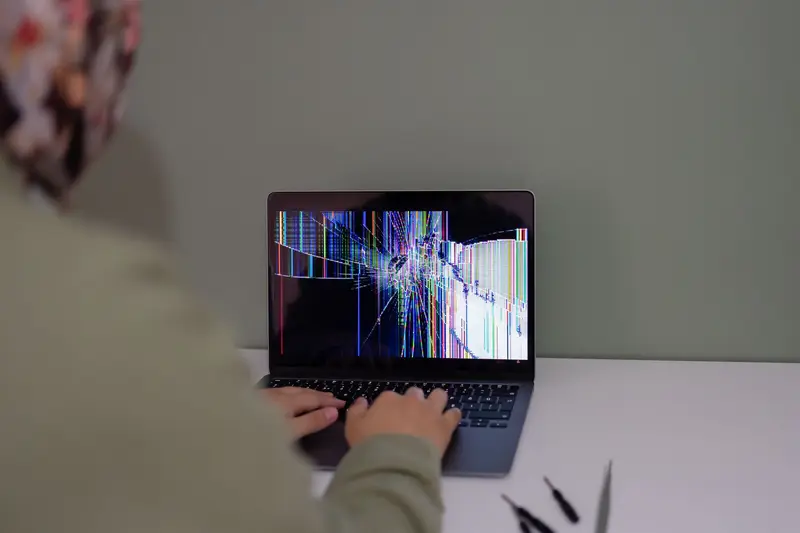 A laptop with a glitching, scrambled screen