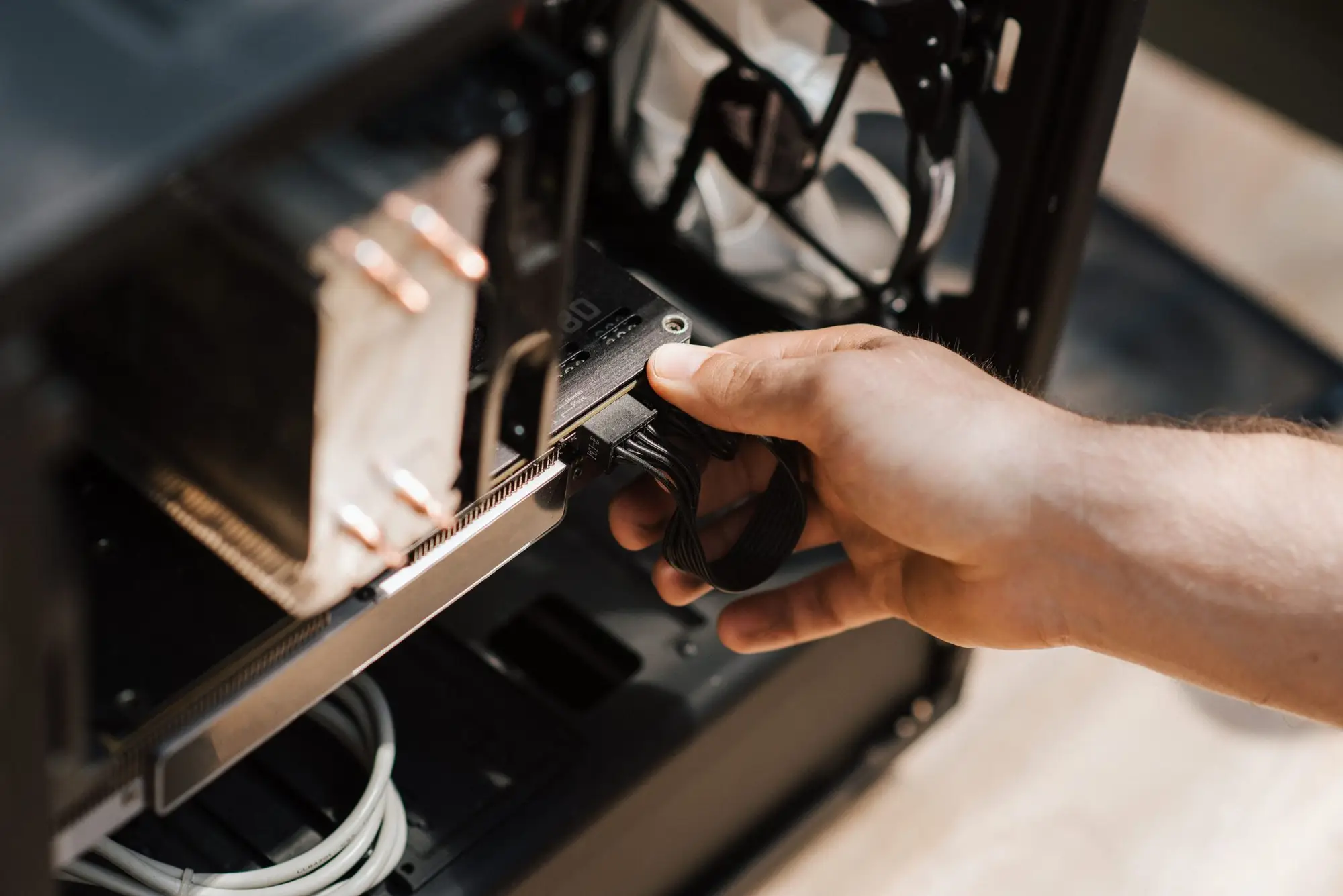 A hand fitting a component inside an open desktop computer case