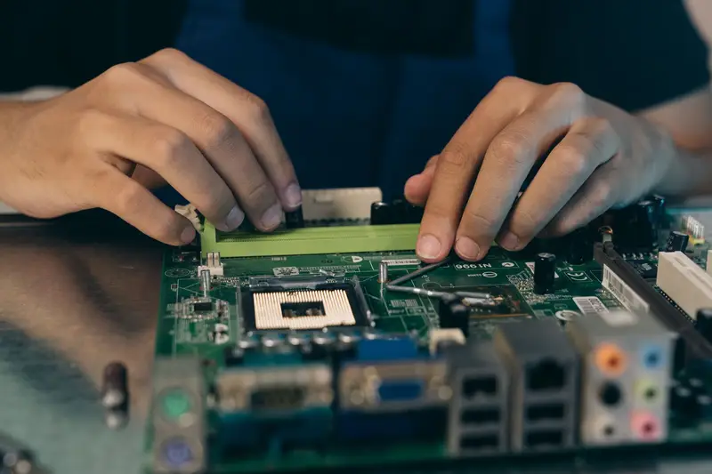 Two hands working on a computer motherboard