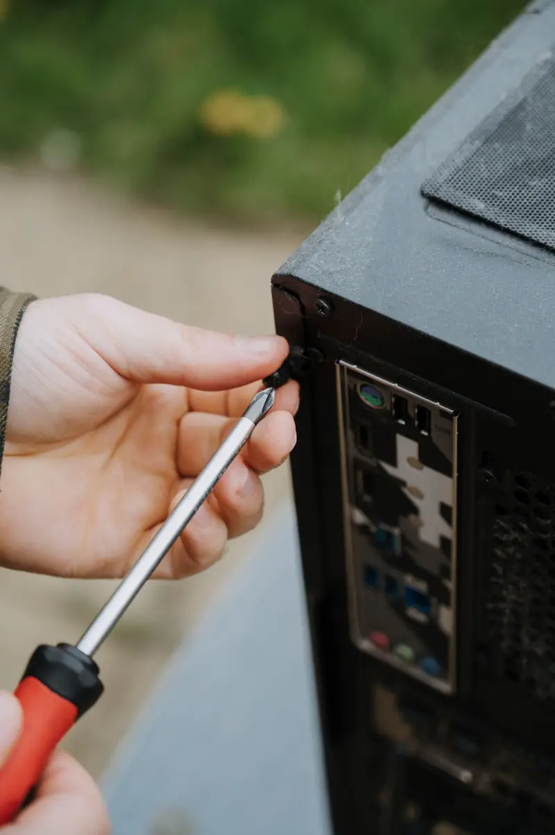 A screwdriver at the back of a desktop computer case